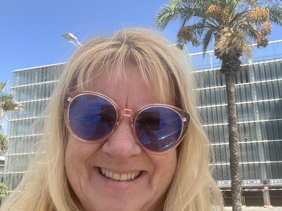 Anne Knapp im Sonnenschein vor einer Palme in Barcelona